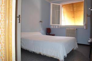 a bedroom with a white bed and a window at Le Logis Charmant in Charmes-sur-Rhône