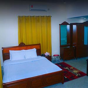 a bedroom with a large bed and a yellow curtain at Eque Heritage Hotel & Resort in Lakshmanpur Bālāpāra