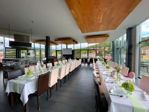 a restaurant with white tables and chairs and windows at Fronveste das alte Knasthaus in Meiningen