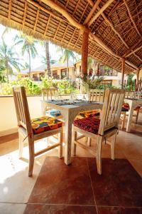 Sansi Kae Beach Resort في ميتشامفي: طاولة طعام وكراسي في غرفة مع طاولة وكراسي