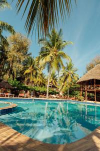 a swimming pool with palm trees and a resort at Sansi Kae Beach Resort in Michamvi