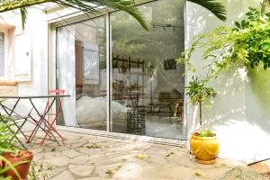a room with a glass door with a table and a plant at L’appartement - Jardin Secret in Marseille