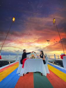 NDC Resort & Spa في مانادو: رجل وامرأة يجلسون على طاولة في سفينة