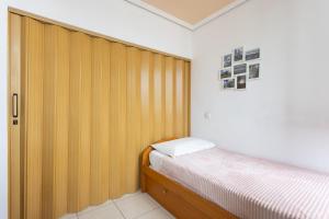 1 dormitorio con cama y tabique de madera en Home2Book Amazing View Apart Floor 25 Santa Cruz, en Santa Cruz de Tenerife