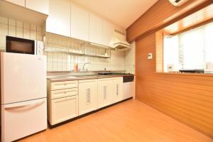 uma cozinha com electrodomésticos brancos e uma parede de madeira em Matoba 6F in Dotonbori em Osaka