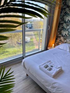 - une chambre avec un lit et une grande fenêtre dans l'établissement Ma Location Sablaise - Appart' Le Chenal, à Les Sables-dʼOlonne