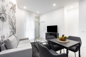 ein Wohnzimmer mit einem Tisch, Stühlen und einem TV in der Unterkunft Home2Book Stunning Apartment Monterosso in Santa Cruz de Tenerife