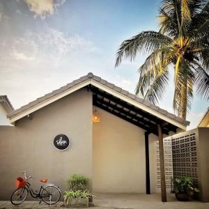 uma bicicleta estacionada fora de um edifício com uma palmeira em Silan Residence, Koh Phangan - An authentic village experience em Chaloklum