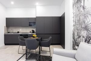 a kitchen with black cabinets and a table and chairs at Home2Book Stunning Apartment Monterosso in Santa Cruz de Tenerife