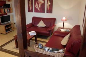 PommerbyにあるFerienwohnung Gartenblickの赤いソファと椅子のあるリビングルーム