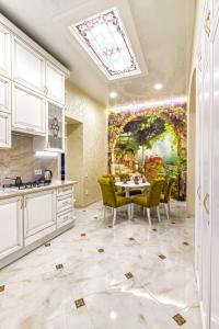 a kitchen with a table and a painting on the wall at Rynok Square city center two bedroom apartment! in Lviv
