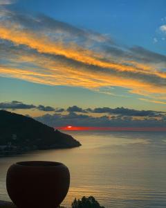 a view of the ocean at sunset with a vase at Fedra Apartments in Poros