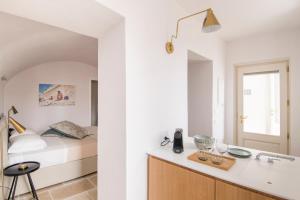 a bedroom with a bed and a sink and a bathroom at Palazzo Mulini in Monopoli