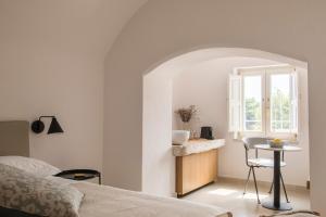 a bedroom with a bed and a table and a window at Palazzo Mulini in Monopoli
