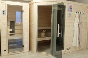 a bathroom with wooden walls and a glass door at Ferienwohnung Innenhof in Pommerby