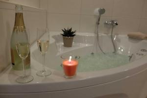 a bathroom with a bath tub with wine glasses and a candle at Ferienwohnung Innenhof in Pommerby