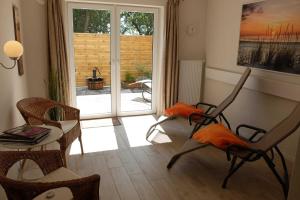 a living room with chairs and a table and a window at Ferienwohnung Innenhof in Pommerby +9 photos