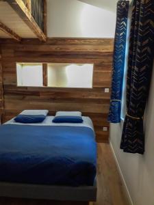 Un dormitorio con una cama con almohadas azules. en Gîte des Augustins - gitesdesbalcons-com, en Crémieu