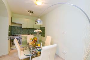 eine Küche mit einem Glastisch und weißen Stühlen in der Unterkunft Apartment Kalea in Dubrovnik