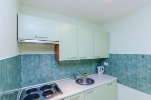 eine Küche mit weißen Schränken und einem Waschbecken in der Unterkunft Apartment Kalea in Dubrovnik