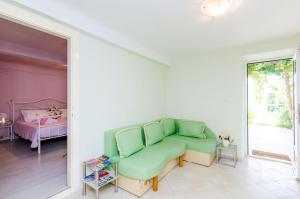ein Wohnzimmer mit einem grünen Sofa und einem Bett in der Unterkunft Apartment Kalea in Dubrovnik