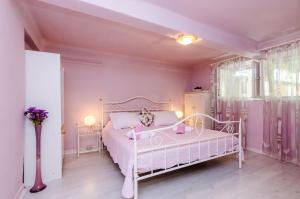 - une chambre rose avec un lit blanc et une fenêtre dans l'établissement Apartment Kalea, à Dubrovnik 30 autres photos