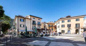 a street in a town with buildings and people at Hotel Du Lac Menaggio in Menaggio