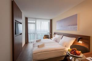 a hotel room with a bed and a table with a bowl of fruit at Hunguest Hotel Panoráma in Hévíz