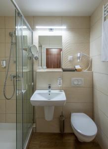 ein Bad mit einem Waschbecken, einem WC und einer Dusche in der Unterkunft Hunguest Hotel Panoráma in Hévíz