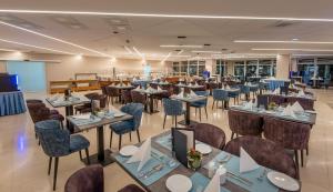 a restaurant with tables and chairs in a room at Hunguest Hotel Panoráma in Hévíz