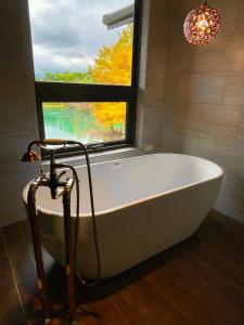 baño con bañera blanca y ventana en Villa 88, en Fengping