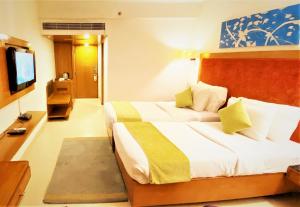 ein Hotelzimmer mit 2 Betten und einem Flachbild-TV in der Unterkunft Gis Select Banjara Hill in Hyderabad