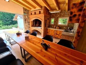 uma sala de jantar com uma grande mesa de madeira e uma lareira em Srce Kozare em Prijedor