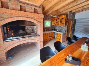 um quarto com uma lareira de tijolo com uma mesa e cadeiras em Srce Kozare em Prijedor