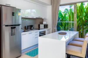 una cocina con nevera de acero inoxidable y armarios blancos en Sunny 3BR Villa with Private Pool at Bangtao Beach, en Bang Tao Beach