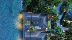 eine Luftansicht eines Hauses mit Bäumen und Lichtern in der Unterkunft Naladhu Private Island Maldives - Special Offer On Transfer Rates For Summer 2024 in Süd-Malé-Atoll