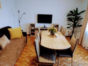 a living room with a wooden table and a couch at ApartamentEMILKA in Kudowa-Zdrój