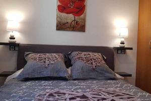 a bedroom with a bed with two pillows and two lamps at Precioso apartamento en El Tarter frente a pistas in El Tarter