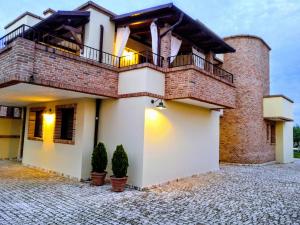 a house with a balcony and two plants at BORGO LUNA b&b in Manduria