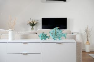 a white living room with a couch with two fish decorations at Ferienwohnungen im HOF68 in Münster