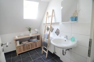 a bathroom with a sink and a towel ladder at Ferienwohnungen im HOF68 in Münster