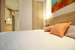 a bedroom with a large white bed with an orange pillow at A Loft You Will Fall In Love With in Tarragona