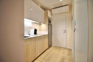 a small kitchen with white cabinets and a refrigerator at A Loft You Will Fall In Love With in Tarragona