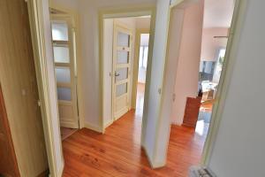 a hallway with two doors and a hard wood floor at APPARTEMENT 1 à 9 personnes Hagetmau coeur de ville in Hagetmau