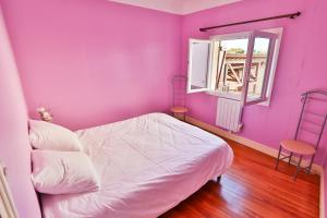 een paarse slaapkamer met een bed en een raam bij APPARTEMENT 1 à 9 personnes Hagetmau coeur de ville in Hagetmau