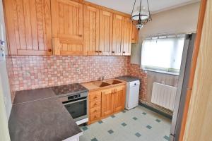 a small kitchen with wooden cabinets and a sink at APPARTEMENT 1 à 9 personnes Hagetmau coeur de ville in Hagetmau