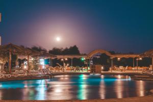 a pool at night with the moon in the sky at Sheikh Ali Dahab Resort in Dahab