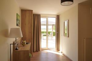 a living room with a door leading to a patio at Hotel Pachernighof in Velden am Wörthersee
