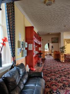 a living room with a leather couch in a room at Inglewood Palm Hotel, Abbey Sands Torquay in Torquay