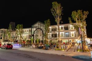 a group of people sitting outside of a building at night at Anona Beachfront Phuket Resort-SHA EXTRA PLUS in Patong Beach